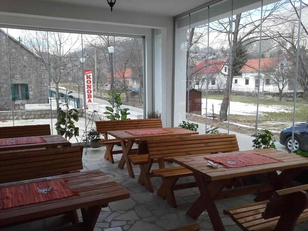 Konoba dining room with wooden tables and mountain views